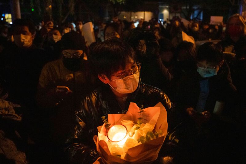 ▲北京民眾27日晚間舉白紙抗議中國防疫政策，並在為烏魯木齊火災罹難者舉行的守夜活動點亮蠟燭。（圖／美聯社／達志影像）