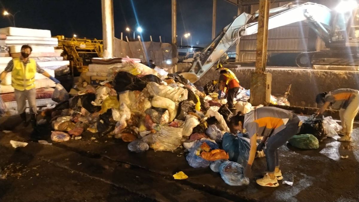 ▲梧棲區清潔隊將垃圾傾卸於隊部空地，在成堆的垃圾找到藍色垃圾袋內的現金收納袋(圖／環保局提供2022.12.6)