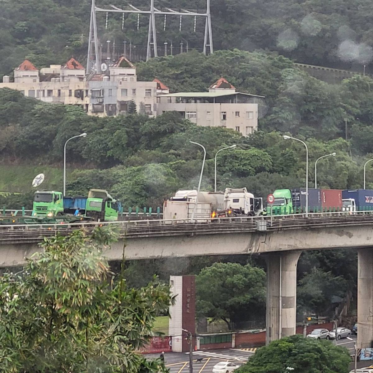 ▲今（4日）下午3時20分，基隆市台2己北向0.7里處發生一起車禍，一名39歲的謝姓男子駕駛聯結車，行經該處後方貨櫃向左側翻覆，最終車頭撞上中央分隔島才停下。(圖/翻攝畫面)