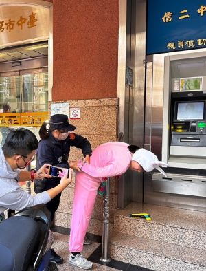 ▲兔兔搶匪在銀行ATM前，被員警當場逮捕上銬（圖/記者鄧力軍翻攝）