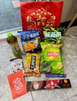 ▲200元福袋內含保底的零食飲料，有A至L共12種組合，每袋另附1款贈品及抽獎券，如圖中開箱贈品是咒術餐具墊組。（圖／記者黃韻文攝）