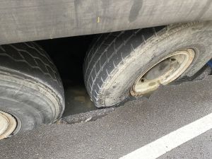 ▲一輛吊車經過南屯區三厝街時，路面突然塌陷，車輪陷入受困。（圖／台中市政府）