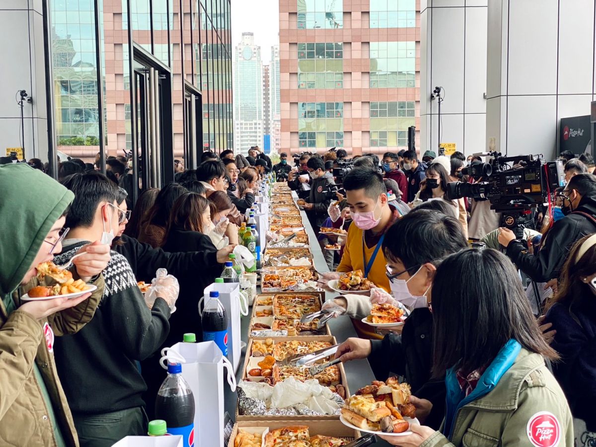 ▲2023年最狂開工，必勝客在台北市信義區號召百人開嗑「巨飽20公尺比薩」派對！長達20公尺的究極加長版巨飽盒一字排開陣容超驚人。（圖／記者蕭涵云攝）