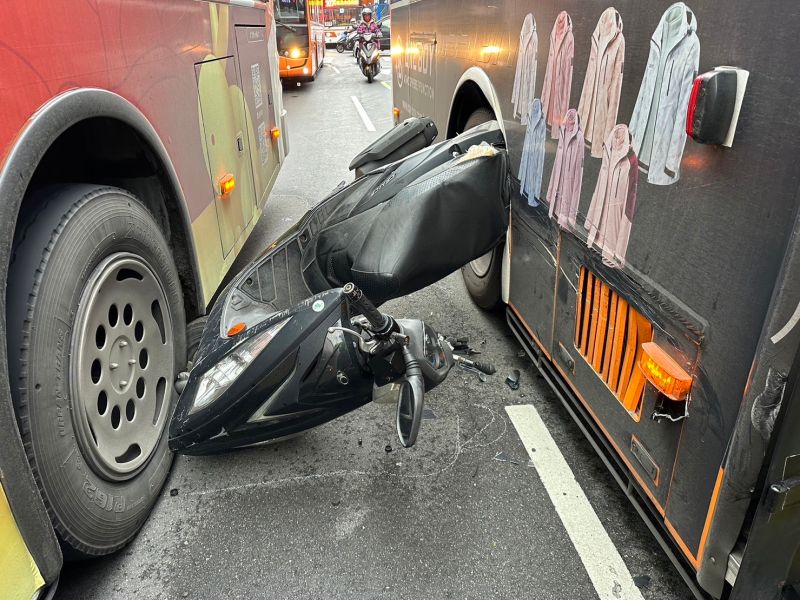 ▲台北市萬華區今早發生一起車禍，一輛機車宛如夾心餅乾遭兩輛公車左右夾擊，整輛機車甚至離地騰空，幸好騎士摔倒後僅受輕傷。（圖／翻攝畫面）