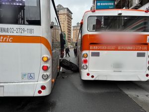 ▲台北市萬華區今早發生一起車禍，一輛機車宛如夾心餅乾遭兩輛公車左右夾擊，整輛機車甚至離地懸空，幸好騎士摔倒後僅受輕傷。（圖／翻攝畫面）