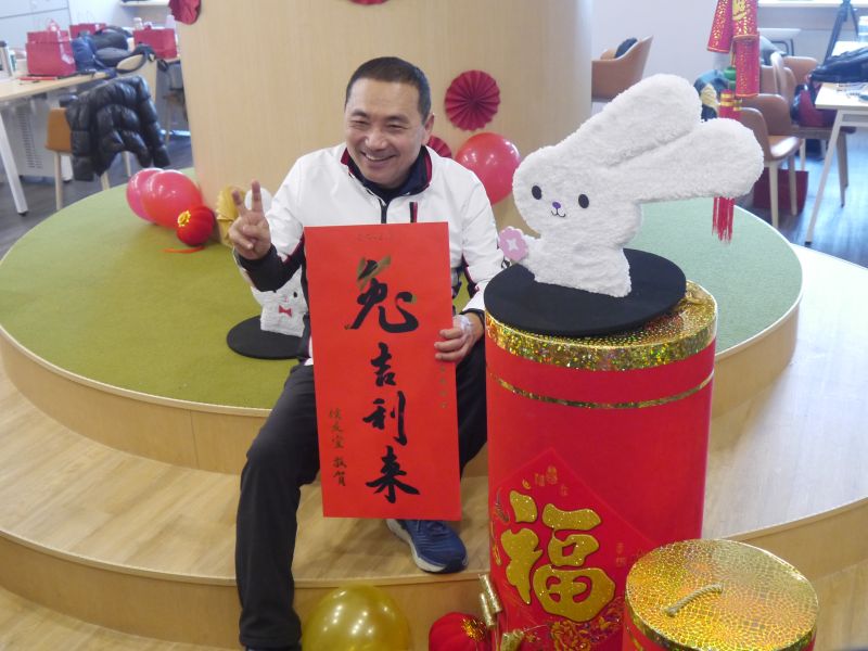 ▲侯友宜開箱2023癸卯兔年春聯福袋，比兔耳「YA」喊你我好大家共好。（圖 ／記者吳嘉億攝，2023.01.05）