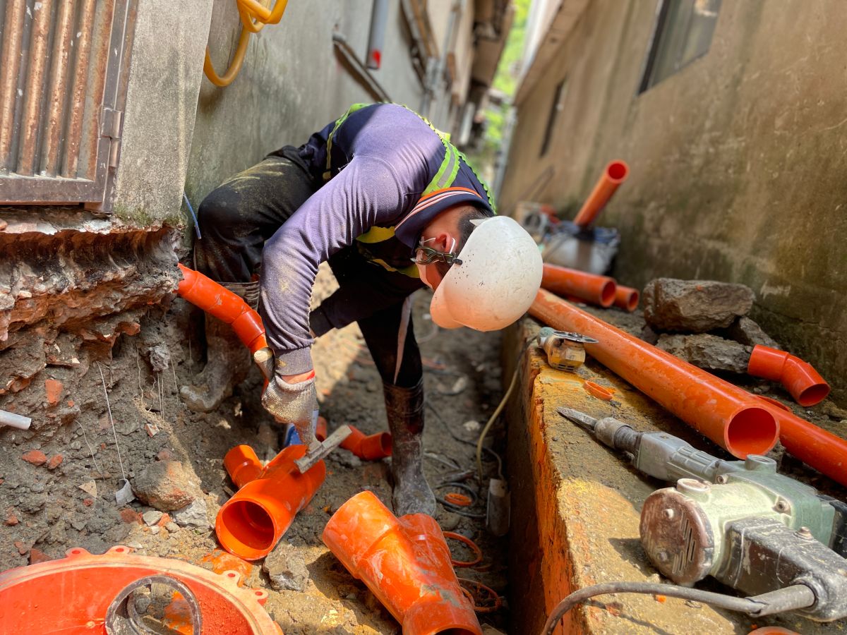 ▲新北汙水接管破百萬，拚115年完成130萬戶，圖為施工人員在髒亂後巷中進行用戶接管。（圖 ／新北市政府水利局提供）