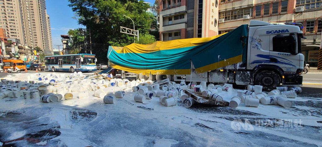 ▲大貨車駕駛許姓男子今天載運水泥漆行經新北市新店北宜路時，疑因固定繩索鬆脫，導致約50個油漆桶脫落翻倒，染白路面。（圖／中央社）