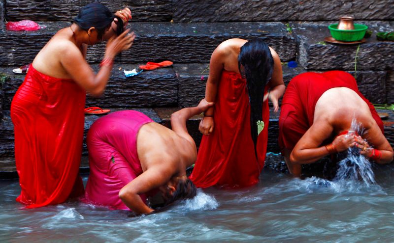 ▲經血在印度教中被認為是「不潔」。圖為尼泊爾印度教婦女在河中沐浴，洗淨「經期間所犯下的罪惡」。（圖／美聯社／達志影像）