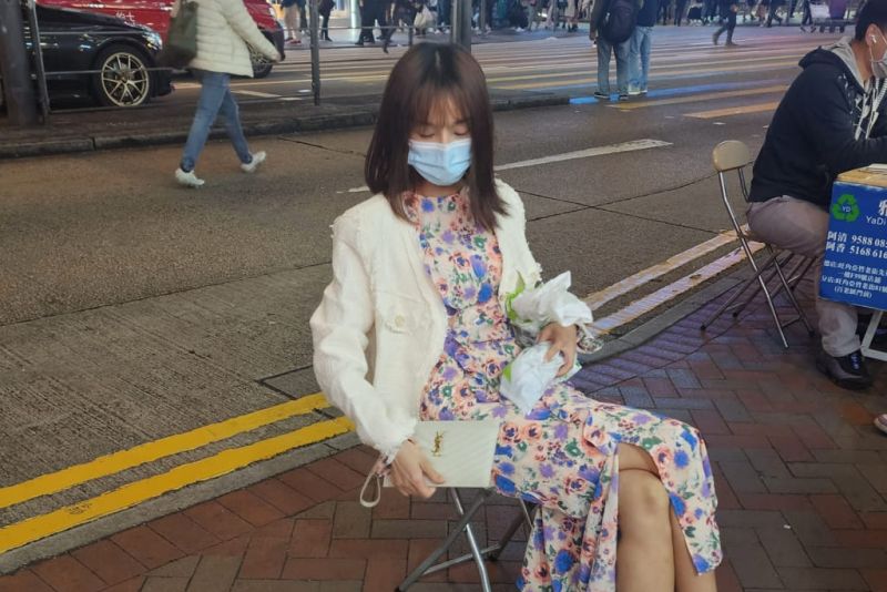 ▲香港旺角街頭，昨（6）日有一位女子，自備了板凳和手寫看板，聲稱想要「賣身葬父」，引發熱議。（圖／翻攝自爆廢公社二館臉書）