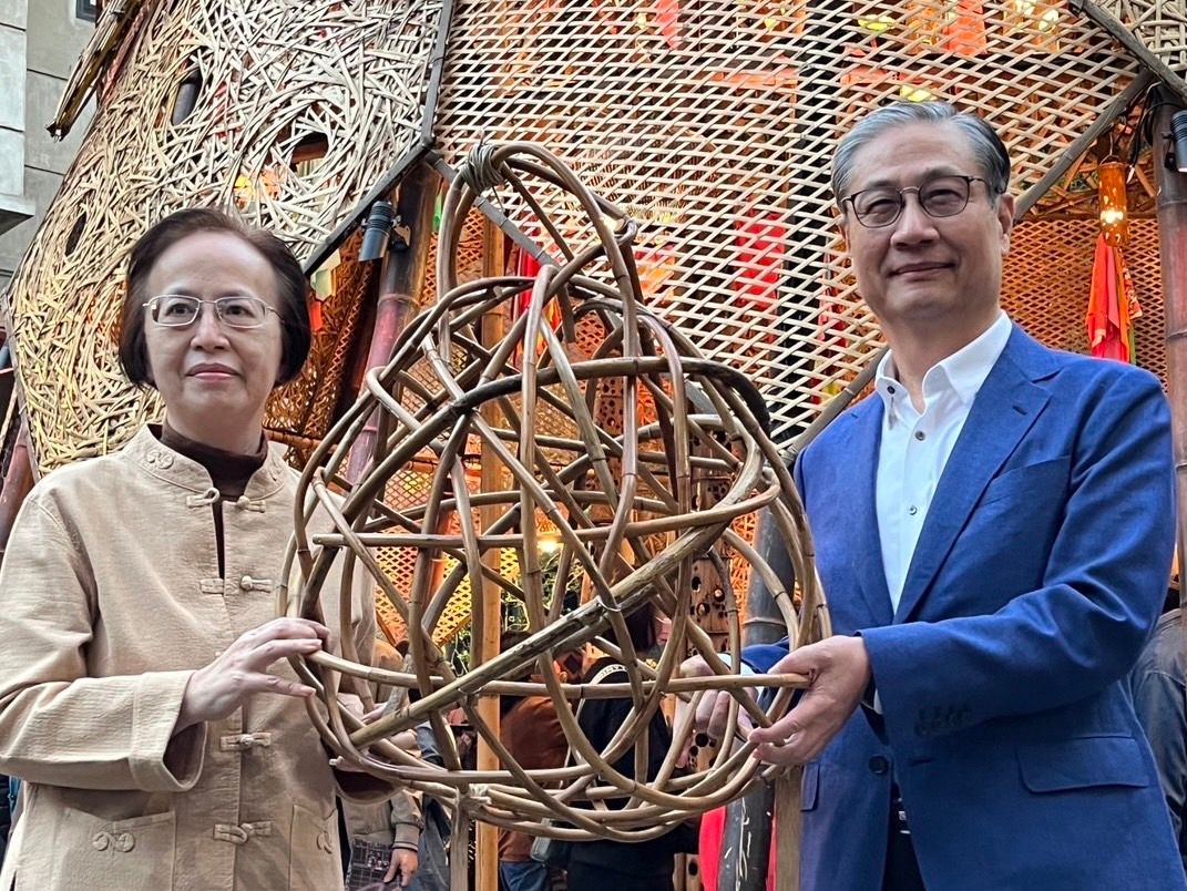 ▲移民署署長鐘景琨參觀新住民燈區，於大型創作「我們在這」上落款，並與台北市政府民政局副局長許敏娟合照。（圖／移民署提供）