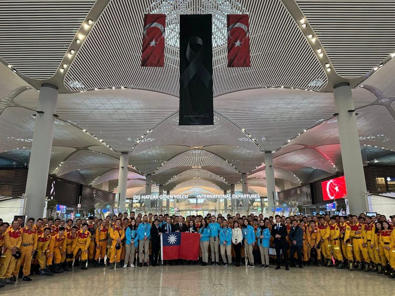 ▲台灣搜救隊員們在伊斯坦堡機場搭機返國，獲得當地民眾和機場工作人員的掌聲致謝，隊員們與國旗合照。（圖／翻攝自台灣駐土耳其代表處臉書）