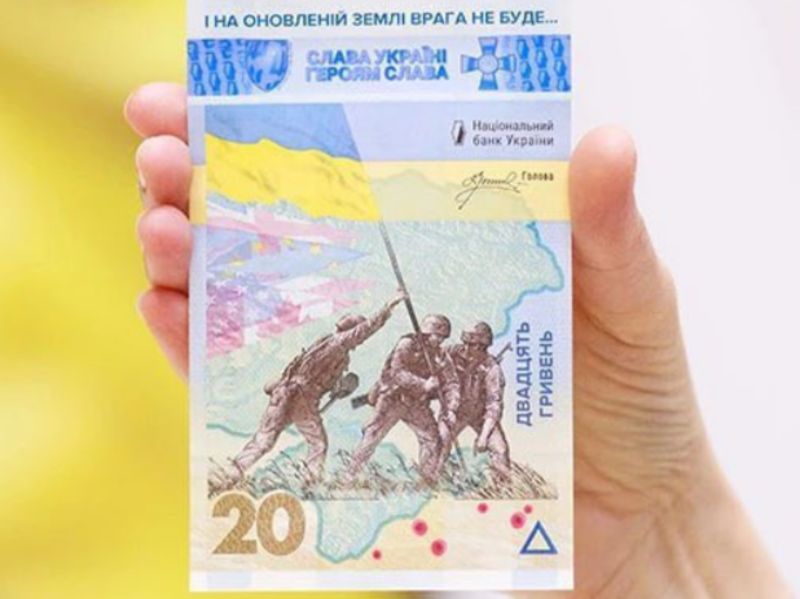 ▲烏克蘭中央銀行23日發行對抗俄羅斯全面入侵週年紀念鈔，上頭描繪3名士兵合力豎起一面烏克蘭國旗。（圖／翻攝自推特）