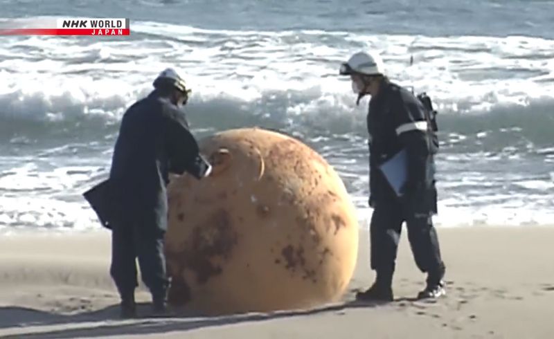 ▲日本靜岡縣海邊發現一顆巨型鐵球。（圖／翻攝自推特@NHKWORLD_News）