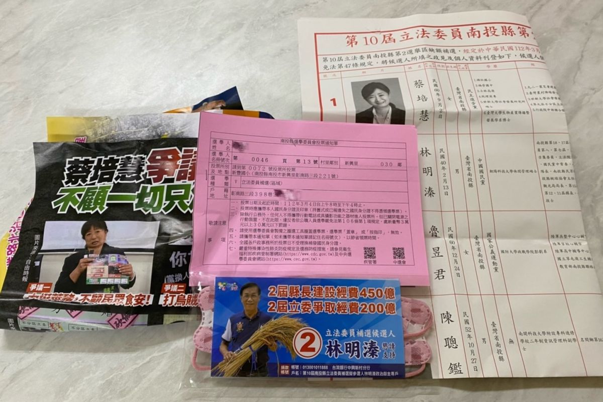 ▲住戶打開選舉公報，裡面的東西琳瑯滿目，有口罩宣傳品，也有攻擊蔡培慧的文宣。（圖／沈夙崢提供，2023.02.26）