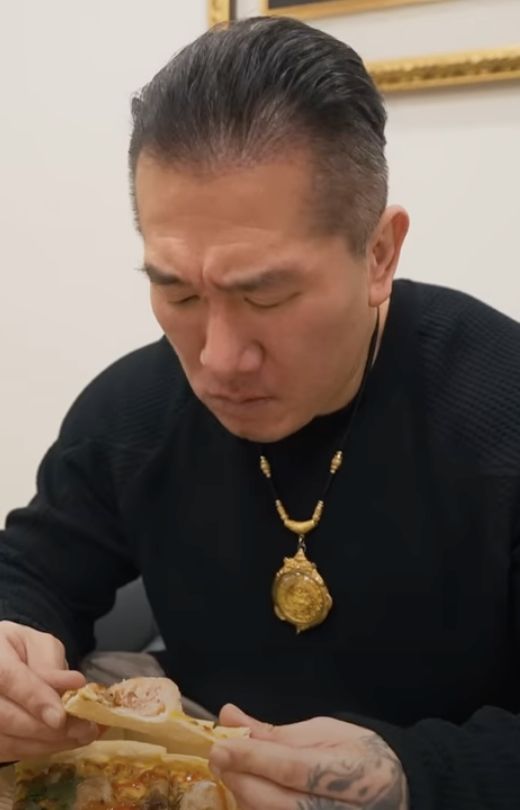 ▲館長吃了一口肉圓披薩之後，眉頭立刻全部皺在一起。（圖/館長YT）