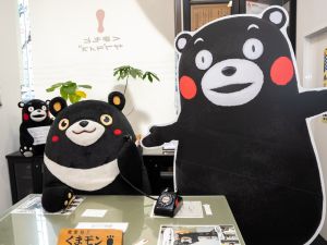 ▲高雄熊坐在熊本熊部長辦公室模擬接電話。（圖／高市府觀光局提供)