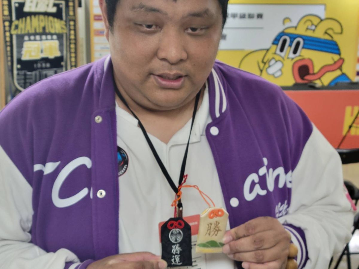 ▲陳定杰秀出自己的兩個勝利御守。（圖／黃建霖攝）