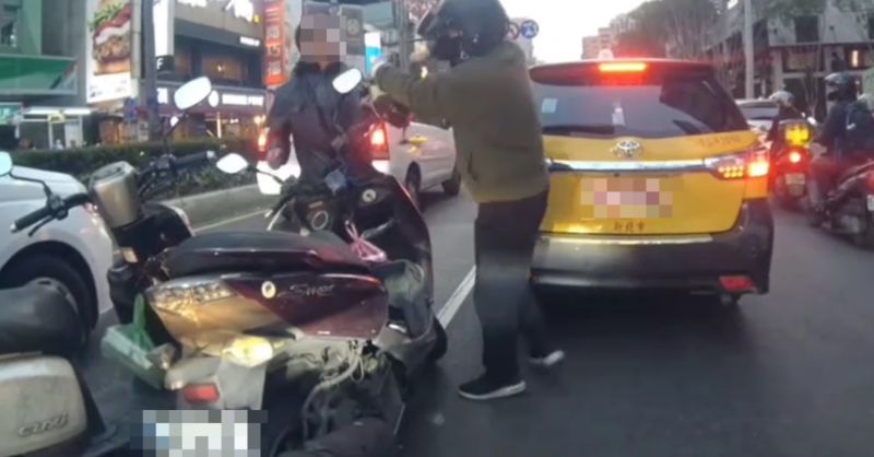 ▲黑衣男子疑似不滿被逼車,手持安全帽揮打另一名機車騎士,過程中還不斷叫囂「給恁爸逼車」,讓路過民眾都嚇壞。(圖/翻攝社會事影音)