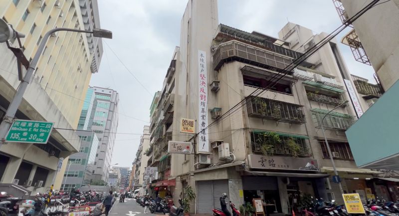 ▲第一殯儀館周邊居民因不滿殯葬業者影響生活，曾在大樓外牆高掛布條抗議。（圖／記者陳建彰攝，2023.03.10）