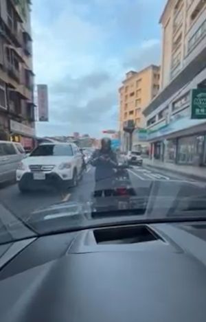 ▲騎士遭鳴按喇叭後,遂擋在路中央攔車。(圖/翻攝畫面) ▲騎士遭鳴按喇叭後,遂擋在路中央攔車。(圖/翻攝畫面)