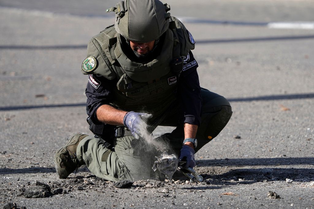 ▲以色列軍方稍早證實，該國北部遭30餘枚火箭彈砲擊。圖為一名以色列警察正在搜集從黎巴嫩發射的火箭殘骸，該火箭落在以色列北部的什洛米。（圖／美聯社／達志影像）