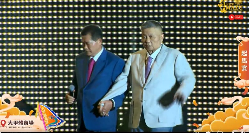 ▲大甲鎮瀾宮副董事長鄭銘坤,牽著董事長顏清標走到舞台中央。(圖/翻攝大甲鎮瀾宮臉書,2023.04.19)