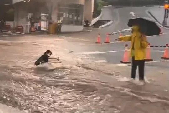 ▲豪雨不斷，台中弘光科技大學學生甚至在過馬路時直接被水勢沖倒。（圖／臉書社群「社會事群組」）