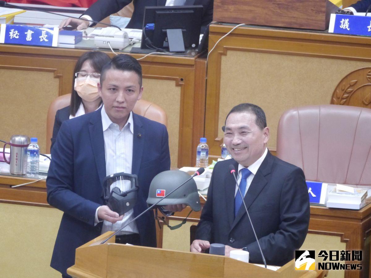 ▲侯友宜到議會進行施政報告，新北議員陳偉杰送上頭盔跟面具。（圖 ／記者吳嘉億攝，2023.04.26）