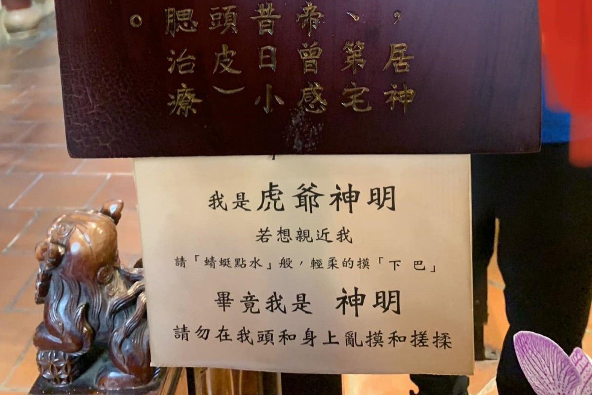 ▲信徒似乎將台南興濟宮的虎爺當貓在疼愛，於是廟方貼出公告，希望眾人輕摸就好。（圖／朱宥勳  臉書）