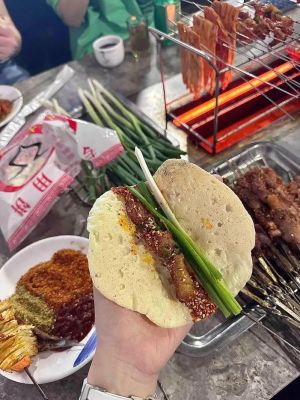 ▲淄博當地烤肉標準吃法「小餅小蔥卷烤串」。（圖／翻攝自時代周報）