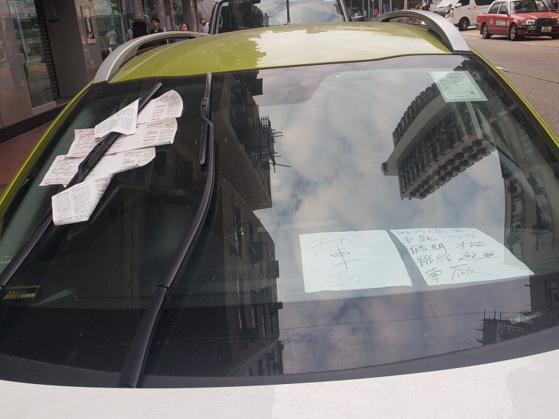 ▲香港民眾在路上看見違停車輛，為規避罰責在車窗前放紙條。（圖／臉書社團《馬路的事討論區》） 