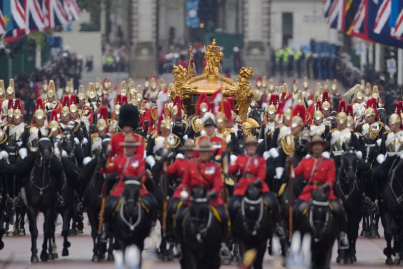 ▲近4000位英國士兵與騎警簇擁,國王查爾斯三世與卡蜜拉王后坐在鍍金馬車上展開返程遊行。(圖/美聯社/達志影像)