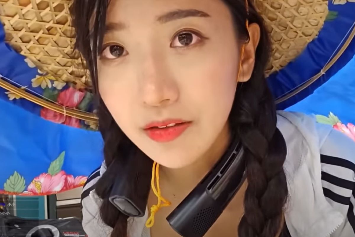 ▲企鵝妹走到苗栗頭份時收到一頂花布斗笠，立刻戴上變身「超正客家妹」。（圖／企鵝妹直播）