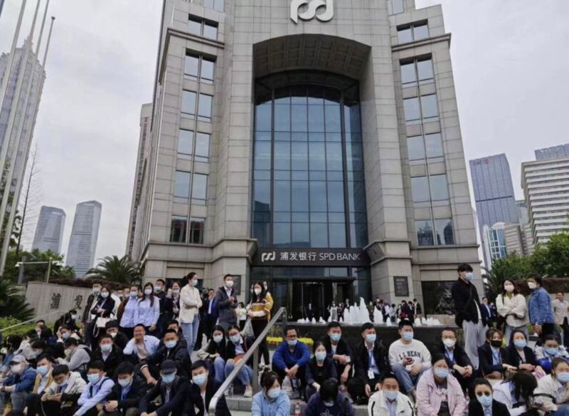 ▲上海浦發銀行11日爆發大規模示威，員工不滿遭砍薪，坐在銀行門口抗議。（圖／翻攝自微博）