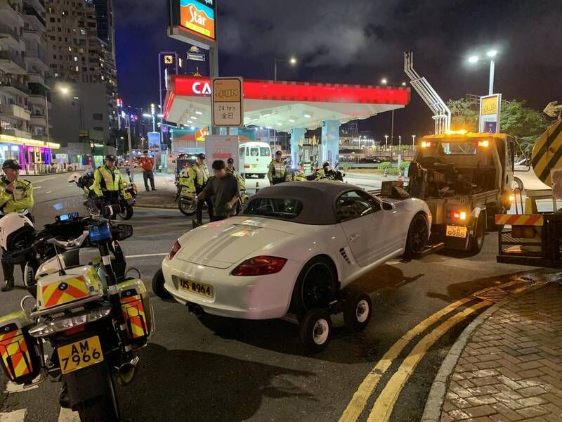 ▲香港一名車牌為「US8964」的保時捷車主無奈表示,自己的愛車在銅鑼灣遭港警包圍,最後被拖吊車帶離現場。(圖/翻攝自臉書社團「地板友 Flat Out Club」)