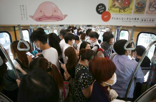 ▲日本電車通勤時段都非常擁擠，搭公眾運輸時把包包放在自己胸前，不僅能讓出更多空間，也可以避免遭扒手偷竊。（圖／美聯社／達志影像）