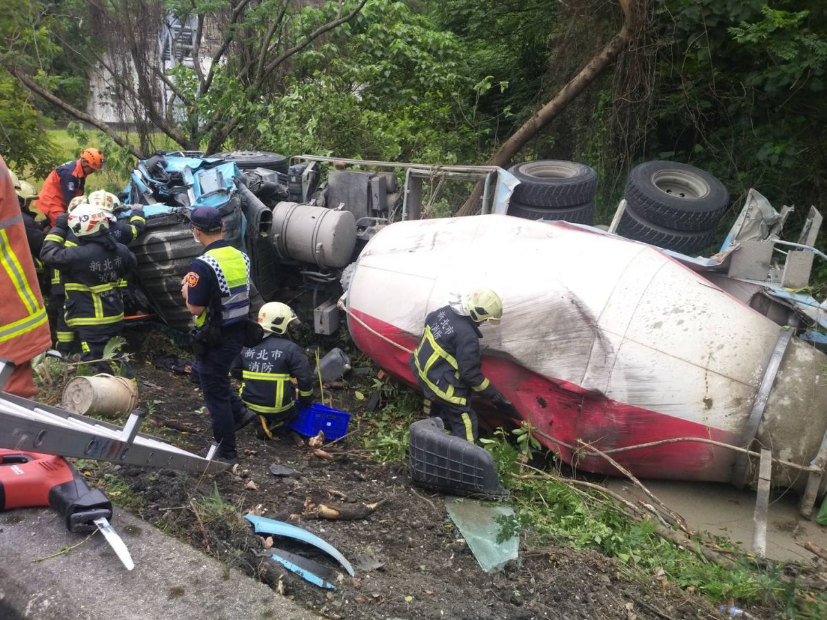 ▲一輛水泥預拌車，在國道3號北上中和交流道匝道出口翻落邊坡，駕駛受困中。（圖／翻攝畫面）