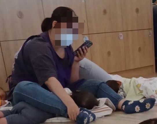 ▲家長不滿托育人員用腿壓幼童滑手機。（圖／白喬茵提供）