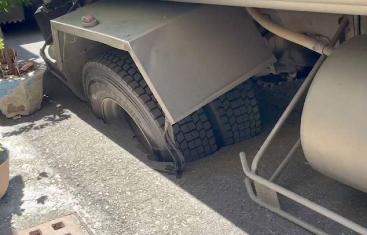 ▲高雄市鳳山新民街今天上午路面突然下陷，１輛運水車陷入洞內。（圖／記者郭凱杰翻攝）