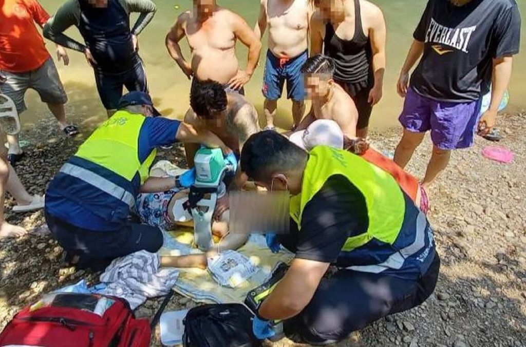 ▲15歲少年9日和家人到新北市坪林區金瓜寮溪玩水時不慎溺水，少年被救上岸時已無呼吸心跳，警消獲報到場對少年實施心肺復甦術，隨後送醫急救挽回一命，目前仍住院觀察中。（圖／翻攝畫面）  