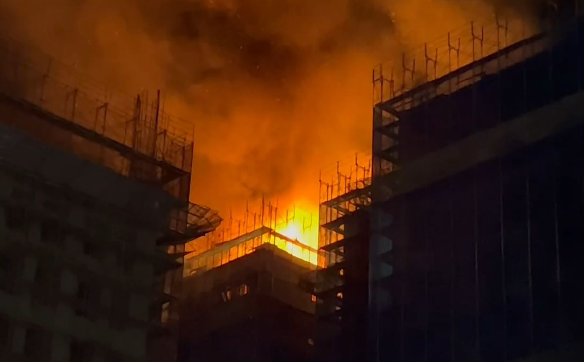 ▲15日晚間，新北三重區仁義街某建案，頂樓(14樓)冒出火煙，消防人員趕抵時，14樓火勢已全面燃燒，隨即佈水線灌救，約1小時後控制住火勢。（圖／翻攝畫面）  