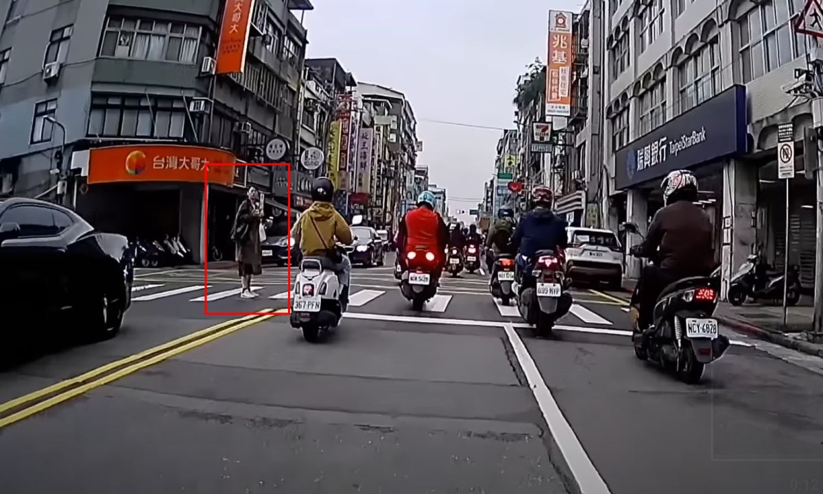 ▲一名行人未獲禮讓，無助站在斑馬線上左右張望，後方騎士全部都錄影下來。（圖/YT@WoWtchout - 地圖型行車影像分享平台）