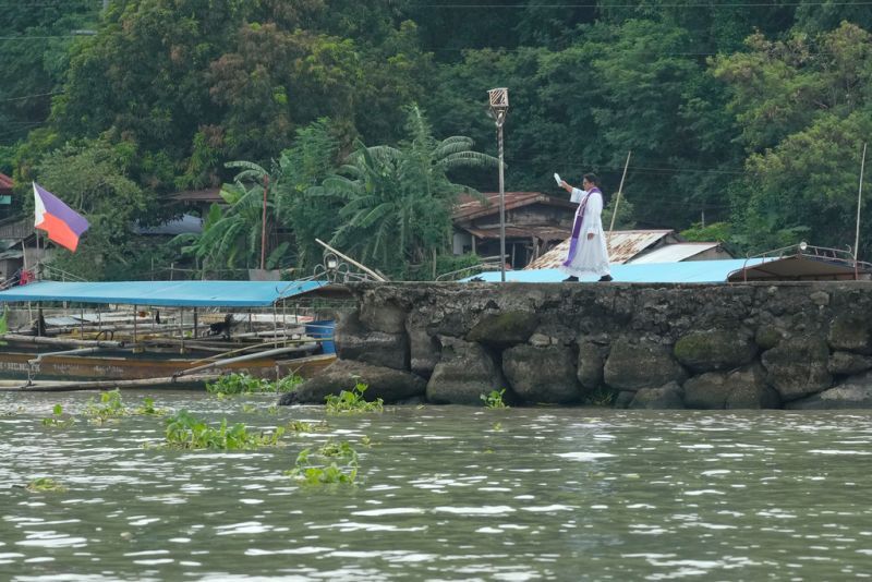 ▲菲律賓一艘渡輪週四在黎扎爾地區的拉古納德灣翻覆，已造成至少26人死亡。圖為神職人員在岸邊進行法事。（圖／美聯社／達志影像）