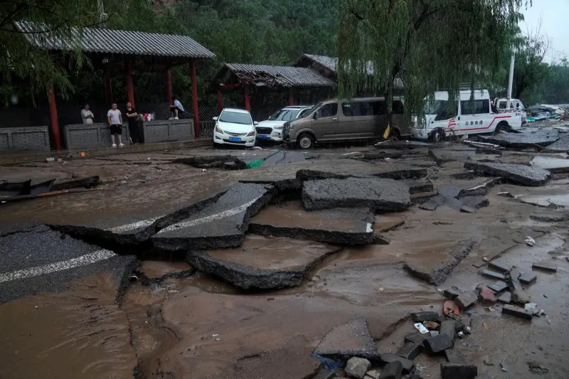 ▲大暴雨導致中國首都北京市多處受災，路面都被沖斷。（圖／美聯社／達志影像）
