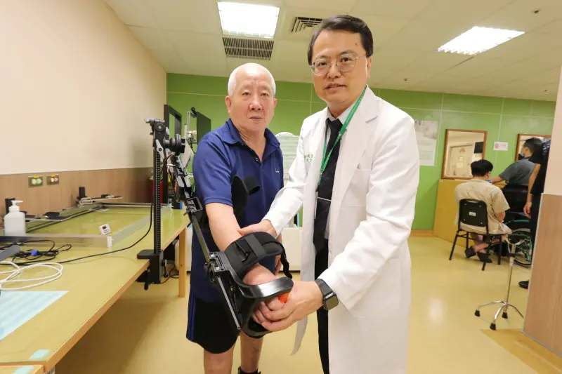 ▲亞大醫院復健部長周立偉指導中風患者使用外骨骼機器人智能輔具，增強復健效果。(圖／醫院提供2023.8.1)