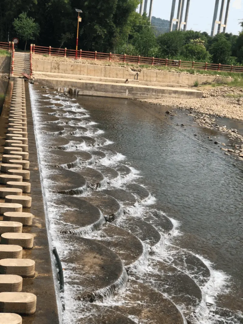 ▲魚鱗壩河道上建有多個魚鱗狀的半圓水壩,是當地知名的遊憩玩水景點。(圖/翻攝自微博)