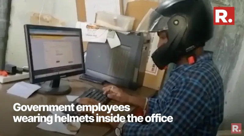 ▲印度一間政府辦公室的員工戴安全帽上班，以防遭天花板砸到。（圖／擷取自YouTube）