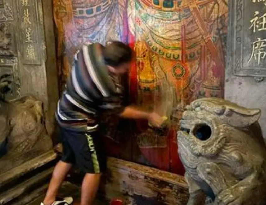 ▲酒醉的西班牙籍男子，疑似嫌「廟門太髒」，竟持清潔劑跟抹布狂擦廟門，此舉導致廟門落漆變白，有民眾發現後隨即報警。（圖／翻攝畫面）  