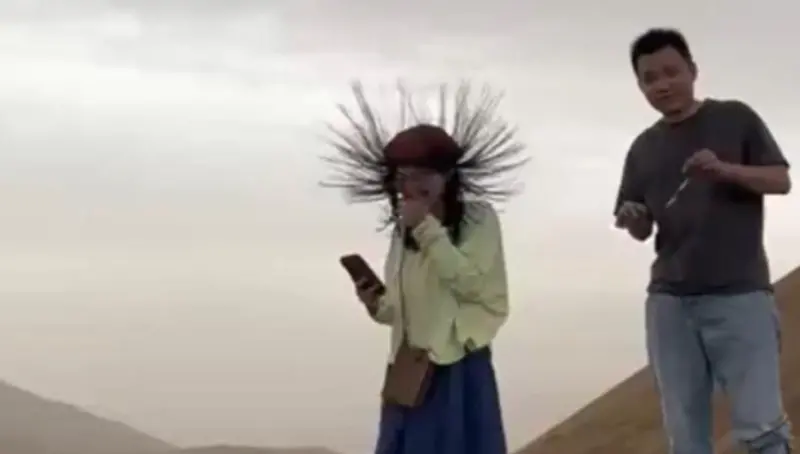 ▲日前在新疆吐魯番，就有導遊帶著遊客欣賞當地沙漠的風貌，沒想到中途幾位女性遊客的長髮，竟然變成「刺蝟」狀，違反地心引力朝向天空豎立起來，導遊見狀則帶著遊客進行避難。（圖／翻攝微博）